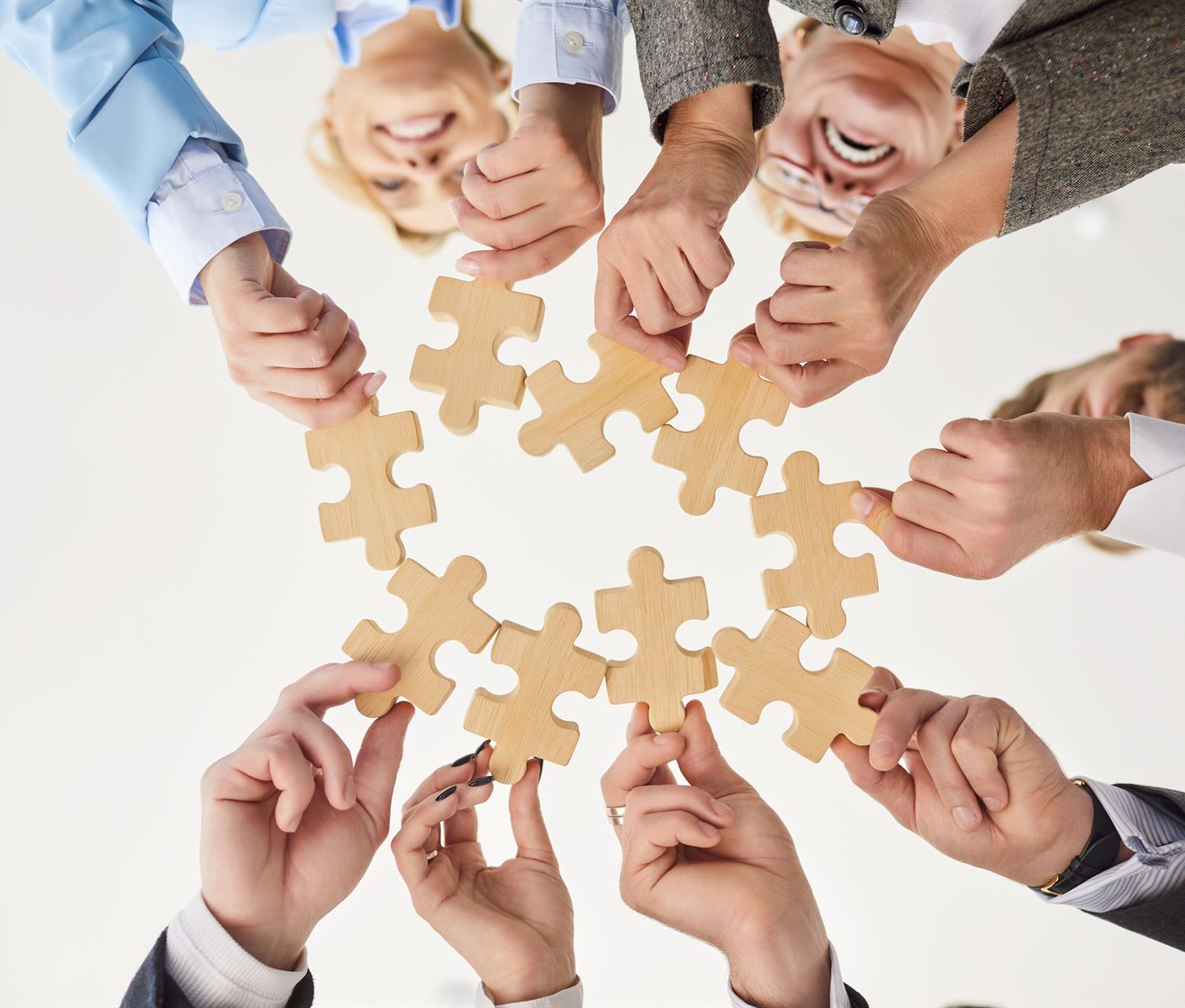 Hands joining puzzle pieces together